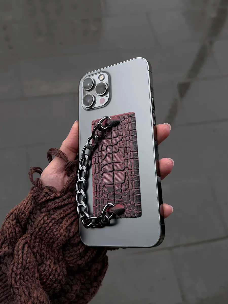 THE GRIP held in hand on phone back
